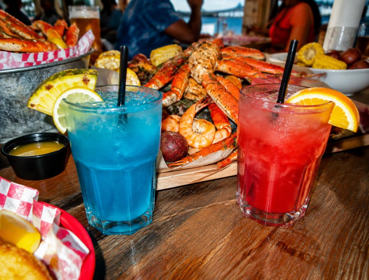 Bright tropical cocktails beside a seafood boil table